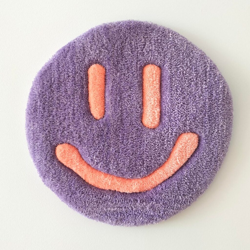 Smiley Wandkleed met paarse smiley.